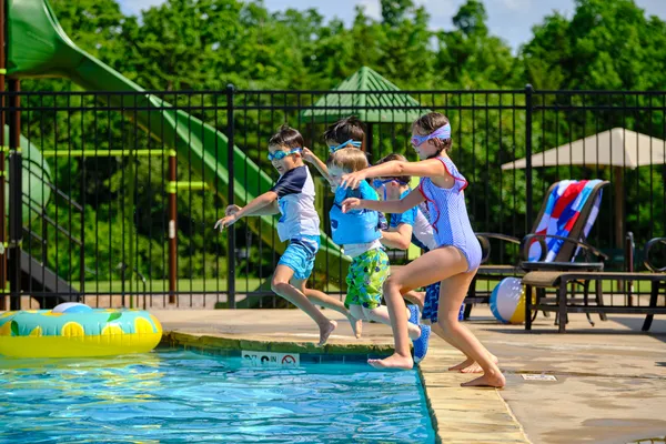  Children jumping into pool in Little River Trails in Norman, OK