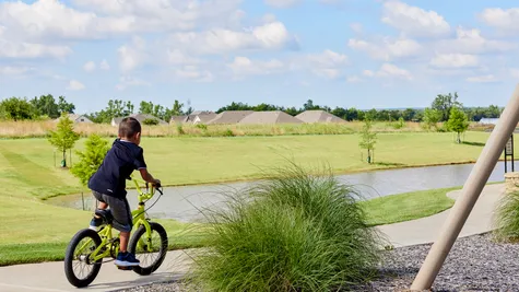  Boy riding bike near pond in Native Plains - new homes in Moore, OK