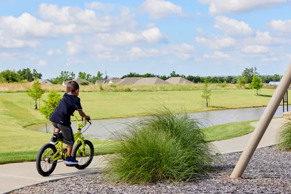  Boy riding bike near pond in Native Plains - new homes in Moore, OK