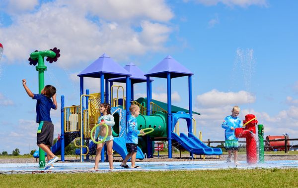 Children at the splashpad and playground in Featherstone - new homes in Moore, OK