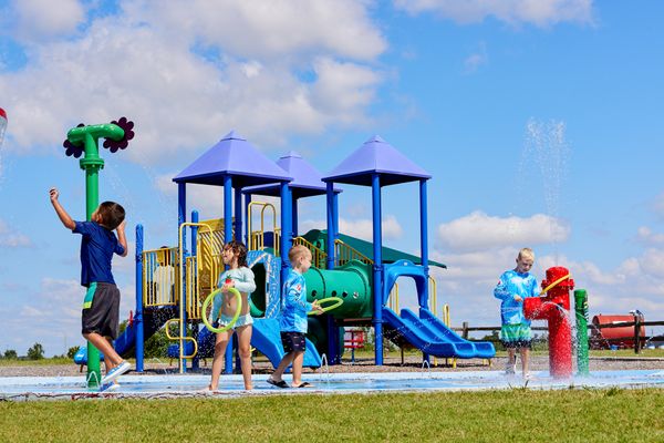 Children at the splashpad and playground in Featherstone - new homes in Moore, OK
