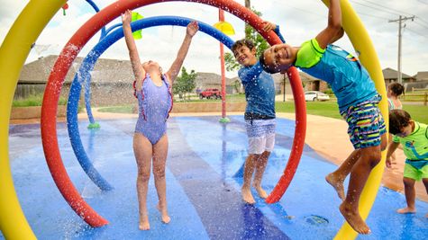 Children at a splashpad in Trail Woods - new homes in Norman
