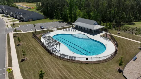 Enjoy the sparkling community pool, including a wraparound pool deck equipped with lounging chairs for sunbathing, exclusive to Windsor townhome residents.