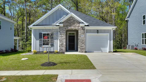 A brand new Ivey Homes ranch plan single-family house with an elegant stone arch entryway, nestled in the serene woodlands of North Augusta, SC 29841.