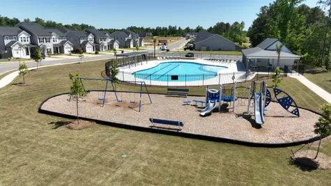 Enjoy playgrounds and the sparkling community pool, including a wraparound pool deck equipped with lounging chairs for sunbathing, exclusive to Windsor townhome residents.