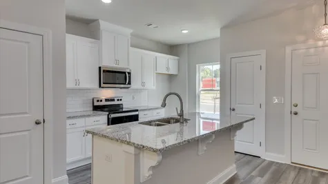 A sleek and stylish kitchen with contemporary design features in the newly constructed townhome for sale at 878 Rachel Branch Forrest Bluff by Ivey Homes, located in North Augusta, SC 29841, showcasing a space that is ready for immediate move-in.