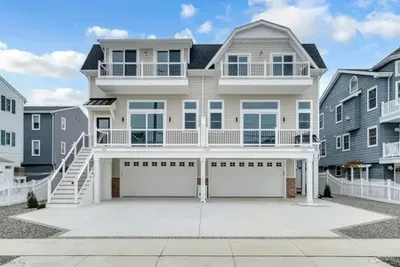 Beach townhomes with two car garages on lower level, white trim, decks on upper levels
