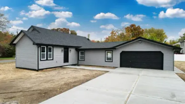 rqanch home with cement driveway 2 car garage gray siding