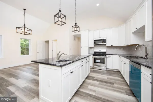 kitchen with grey floor white cabinets stainless appliances