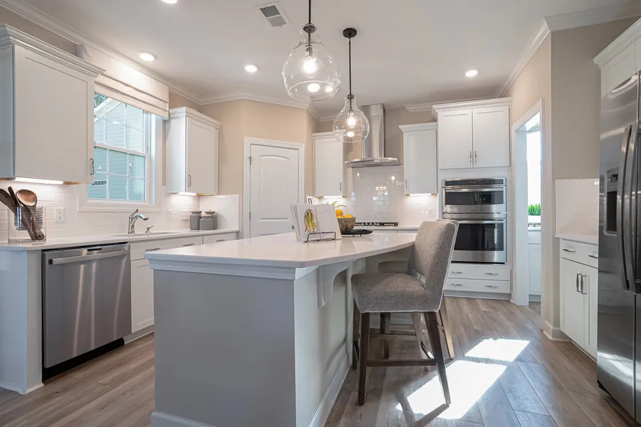 Bright white kitchen with big island and stainless steel appliances in new construction Mungo Home