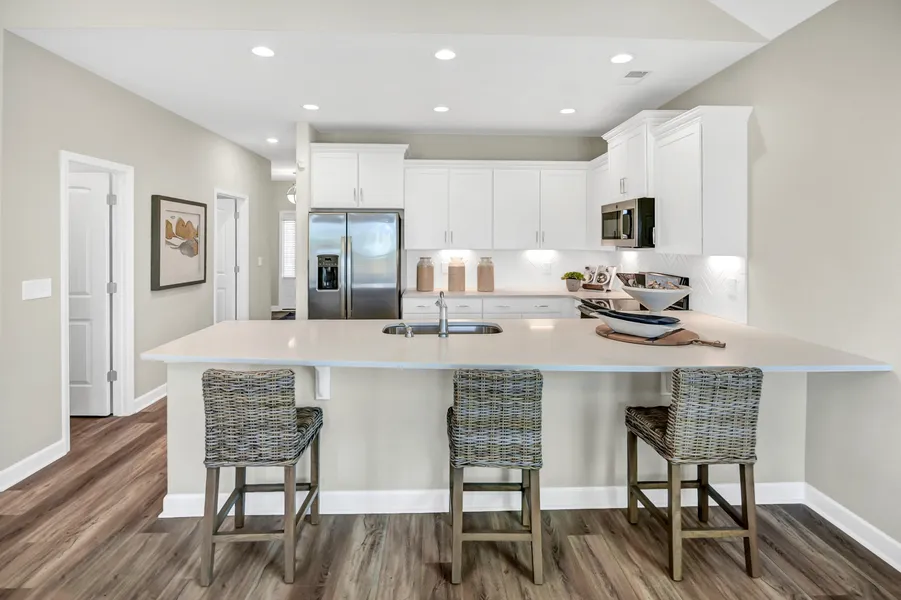 Open concept kitchen with white cabinets in new construction home by Mungo Homes