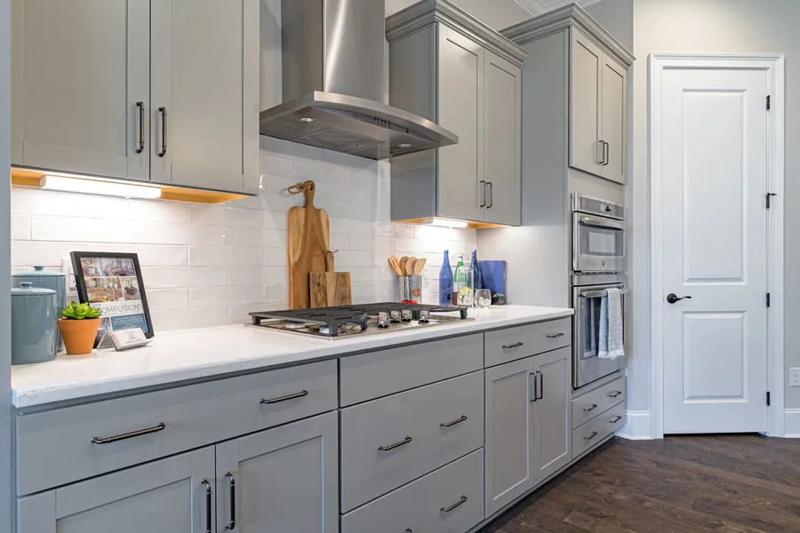 Grey cabinets and white subway tiles in new construction home by Mungo Homes