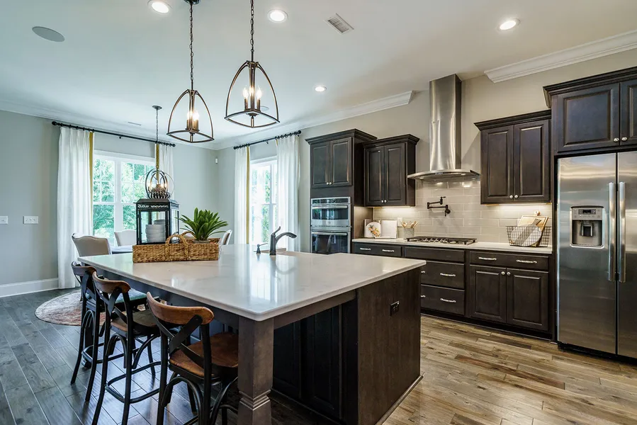 Dark wood kitchen with island open to large great room and eat-in in new construction home by Mungo Homes