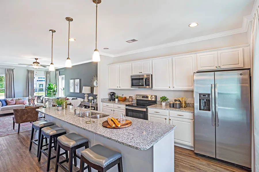 Open concept kitchen with grey granite countertops in new construction home by Mungo Homes