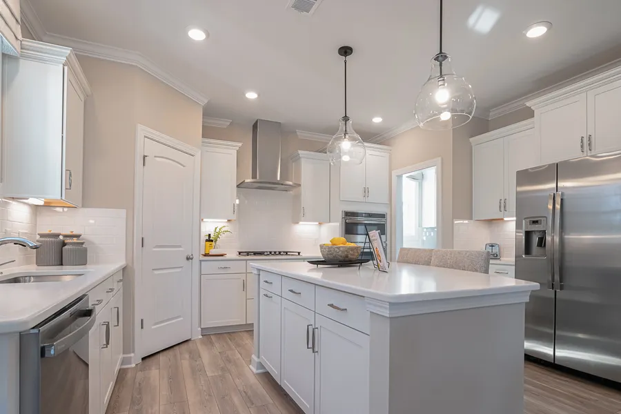 Bright white kitchen with big island and stainless steel appliances in new construction Mungo Home