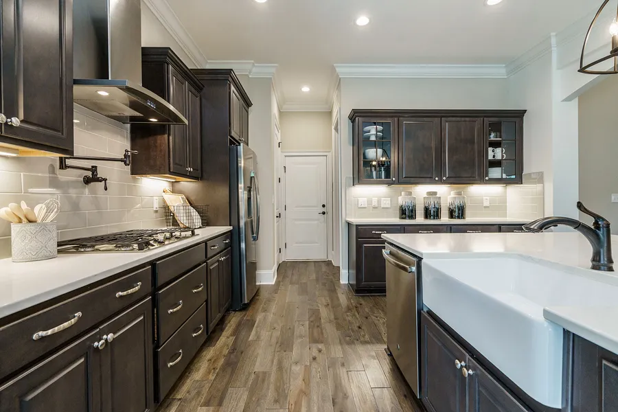 Dark wood kitchen with island open to large great room and eat-in in new construction home by Mungo Homes