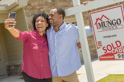 Homebuyers taking selfie outside their new home by Mungo