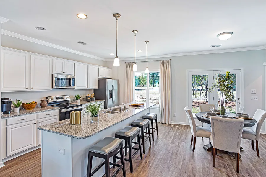 Open concept kitchen with grey granite countertops in new construction home by Mungo Homes