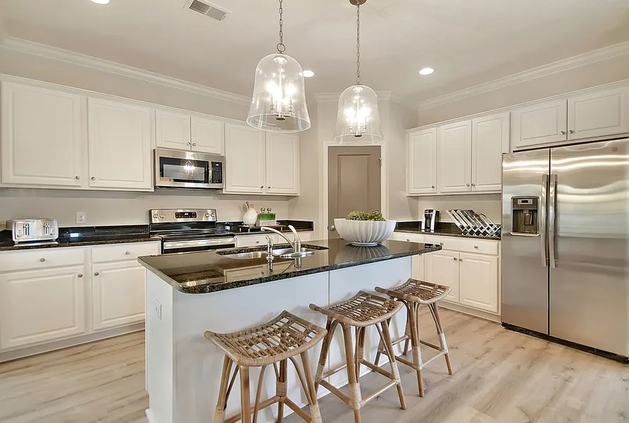 White cabinets with dark countertops kitchen in new construction home by Mungo Homes