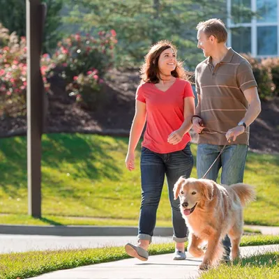 Homeowners walking their dog in their community