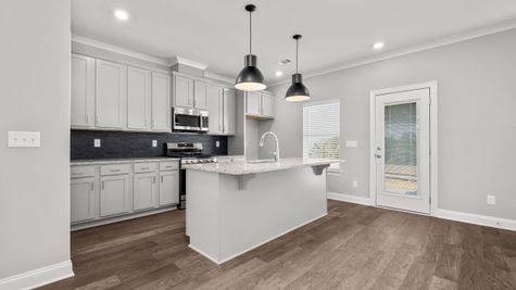 Interior photo of an open concept kitchen with gray cabinets and black accents
