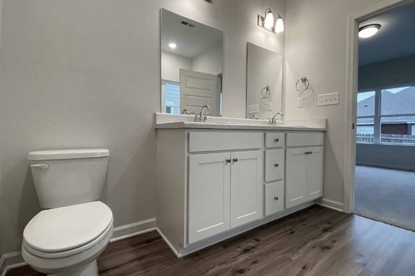 interior photo of bathroom with white cabinets and double sink vanity