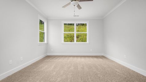 Interior photo of bedroom with gray painted walls, carpeted flooring, and big windows