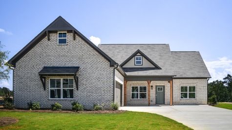 Exterior view of one level home with white brick and dark accents
