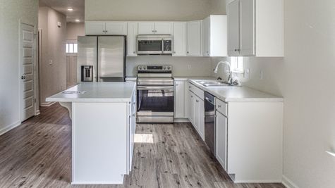 interior photo of kitchen with white cabinets and white countertops