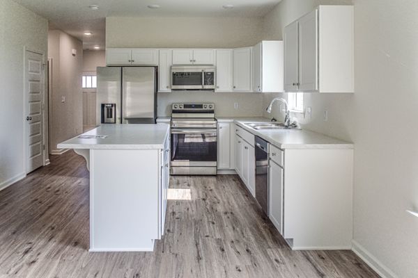 interior photo of kitchen with white cabinets and white countertops
