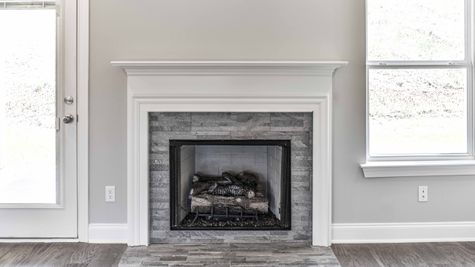 Photo of titled fireplace and white mantle