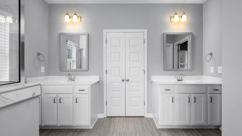 Interior view of Bathroom room with white cabinets, white counter tops, & chrome accents
