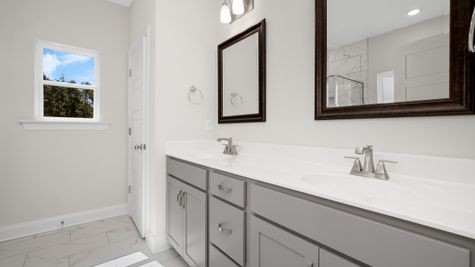 Interior photo of a bathroom with gray cabinets and white counter tops