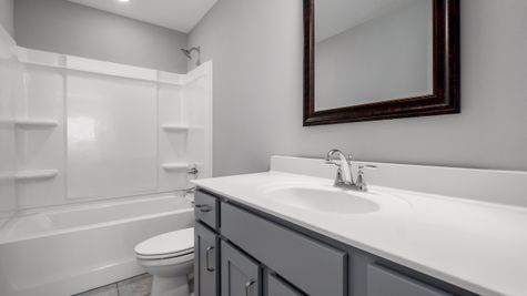 Interior of secondary bathroom with gray cabinets