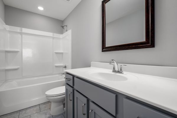 Interior of secondary bathroom with gray cabinets