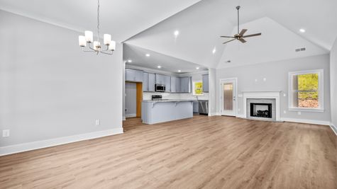 Interior of open concept living room with natural light and grey kitchen cabinets