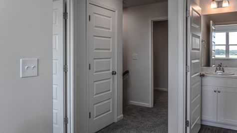 interior photo of hallway with bathroom and bedroom adjacent