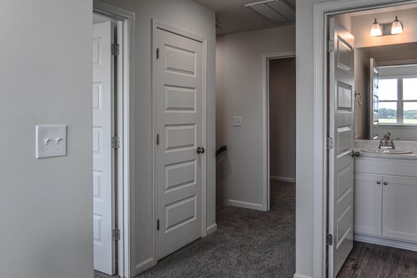interior photo of hallway with bathroom and bedroom adjacent