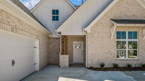 Exterior photo of a one level white and sandy brick home