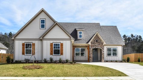Exterior photo of 1.5 story Magnolia floorplan with gray siding, cedar accents, and a blue front door