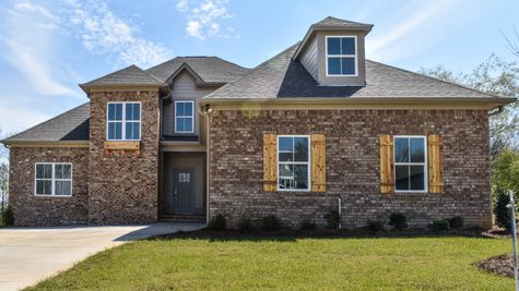 Exterior photo of 2 story brick home with cedar accents and a green front door