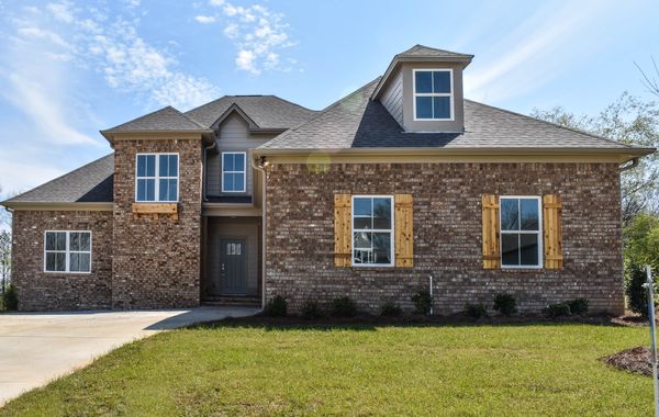 Exterior photo of 2 story brick home with cedar accents and a green front door