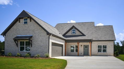 Exterior of one level home with white brick and dark accents