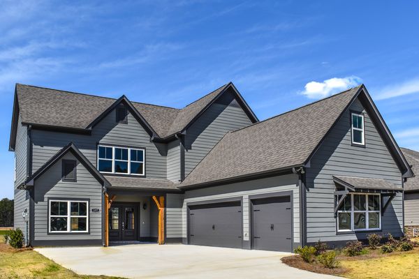 Exterior photo of 2 story Stockmore floorplan with dark gray siding, peppercorn trim, and a peppercorn front door