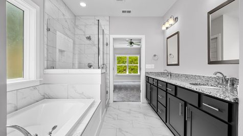 Interior photo of a bathroom with dark cabinets and granite counter tops