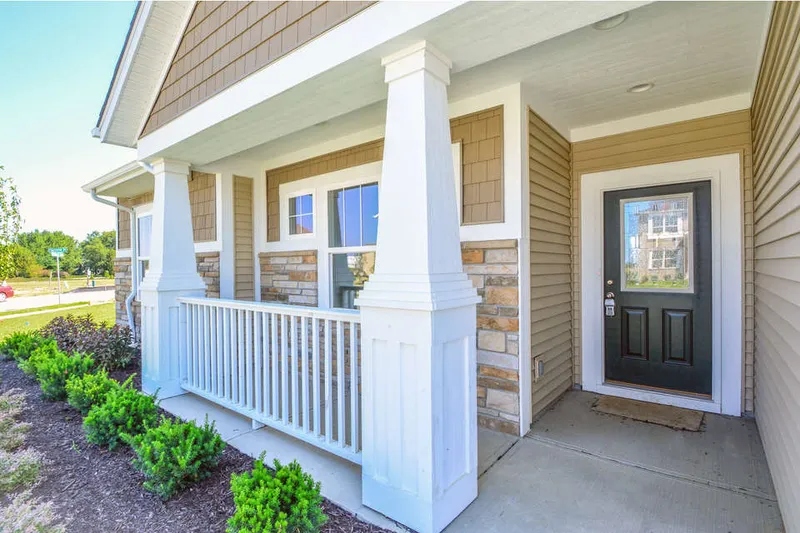 front porch of a new home in dunewood trails community by olthof homes