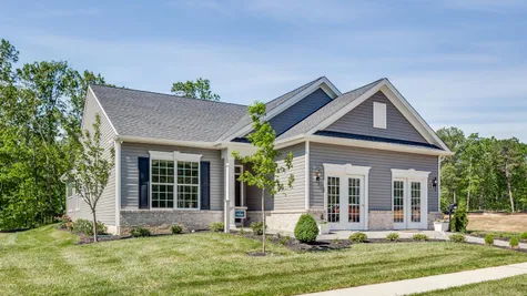 Exterior of the Zinnia sales office & model new home in South New Jersey with gray siding and colonial accents.