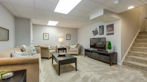 The Laurelton model new home with a finished basement, decorated with carpet and sample furniture.