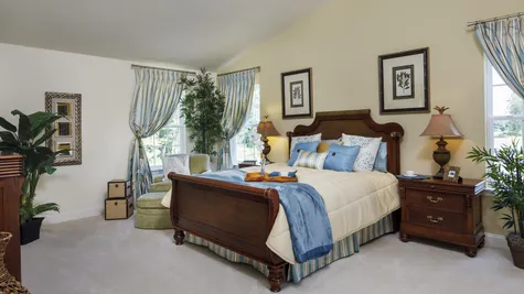 Baldwin model home master bedroom with high ceiling and sample furniture.