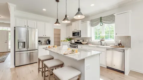 Kitchen in Zinnia model one story new home in south NJ with white cabinets, three pendant lights over center island,
